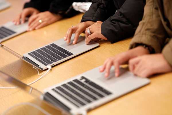 People look at  MacBook Airs at the World Trade Center Apple Store during a Black Friday sales event in Manhattan, New York City