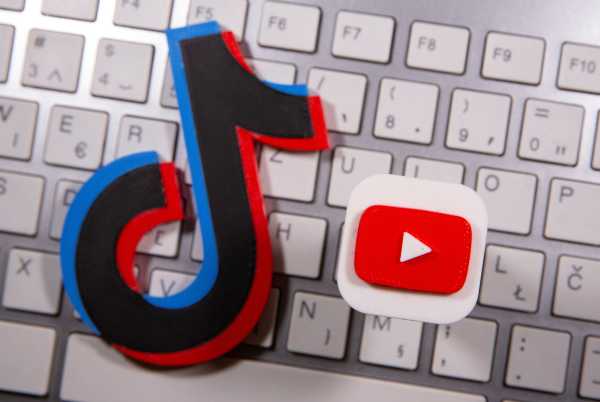 A 3D printed Youtube and Tik Tok logo are seen placed on keyboard in this illustration taken