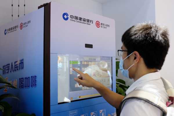 Man uses a vending machine promoting e-CNY in Shanghai