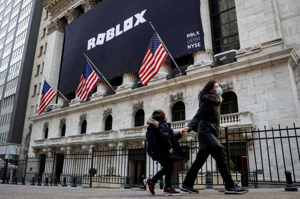 A child looks back at a banner for Roblox, displayed to celebrate the company's IPO at the NYSE is seen in New York